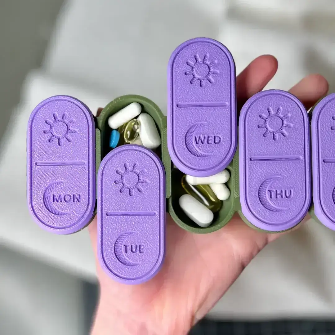 A USACUTTIE pill organizer held in a hand